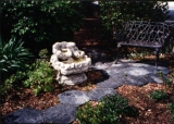 Faux cast iron, cast aluminum bench by fountain